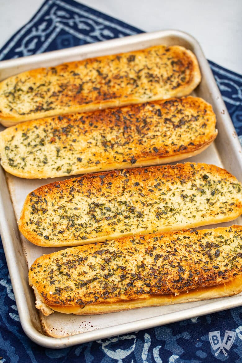 Overhead view of a tray of golden brown homemade garlic bread.