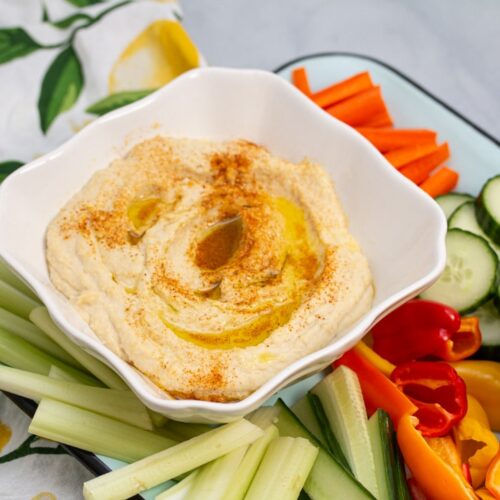 Platter of hummus with fresh veggies and pita chips.