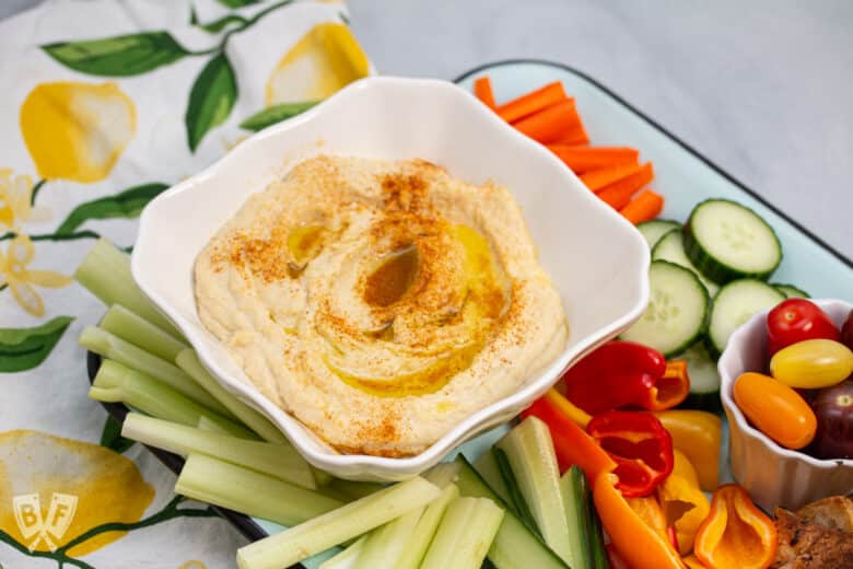 Platter of hummus with fresh veggies and pita chips.