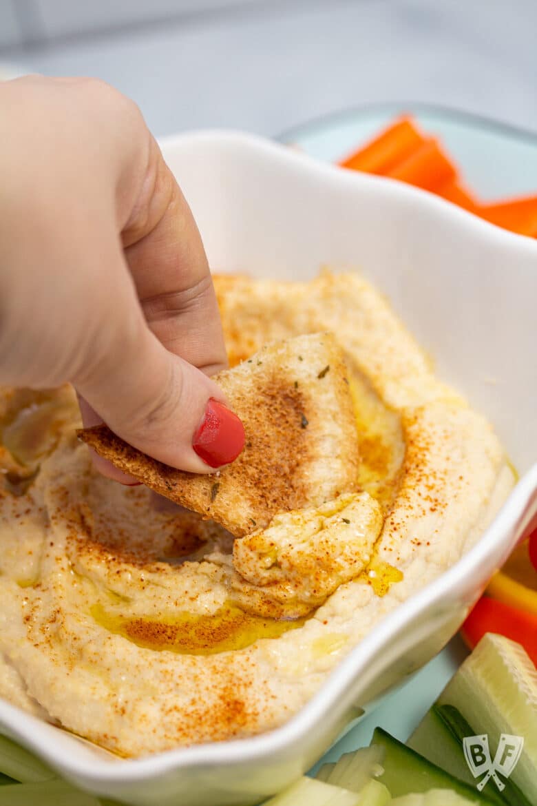 Pita chip scooping up hummus.