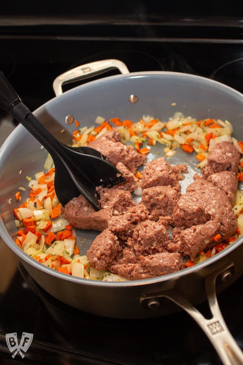 Meat chopper in a skillet breaking up ground meat.