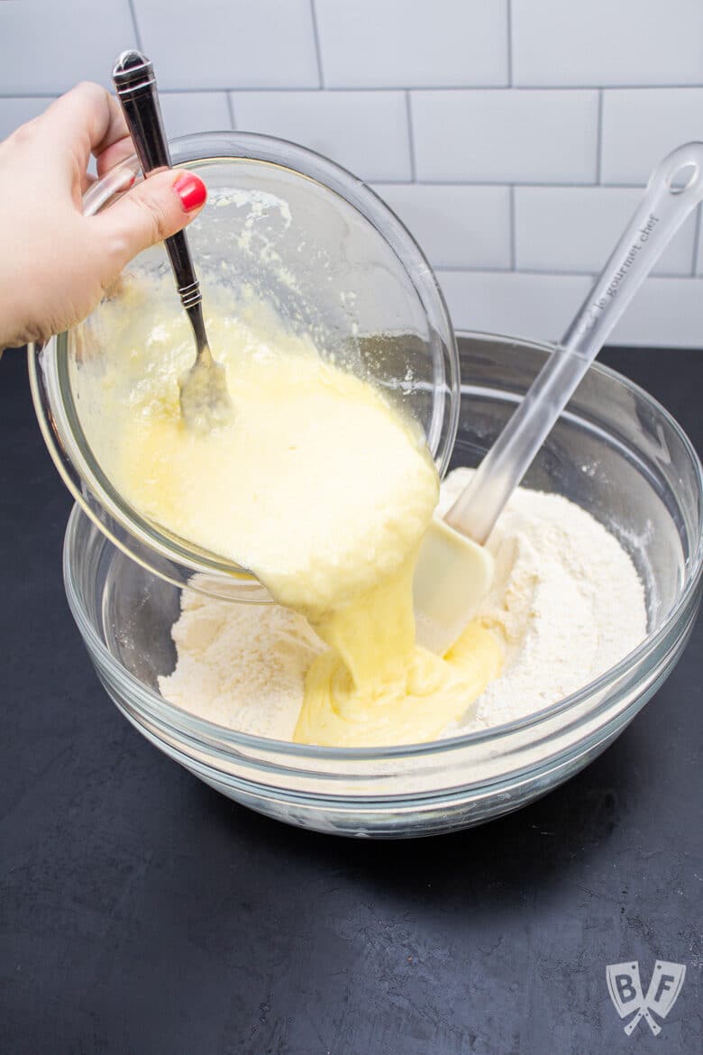 Pouring wet ingredients into dry ingredients for sweet corn muffins.