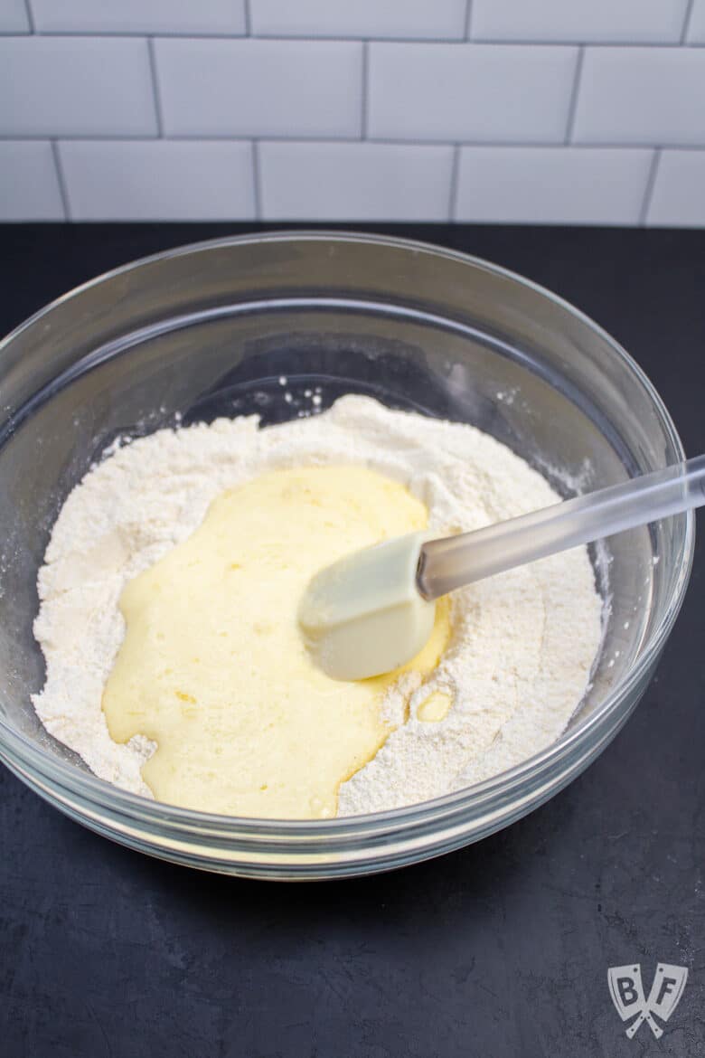 Wet and dry ingredients in a bowl with a spatula, ready to mix.