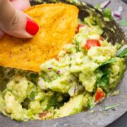 Tortilla chip scooping up guacamole.