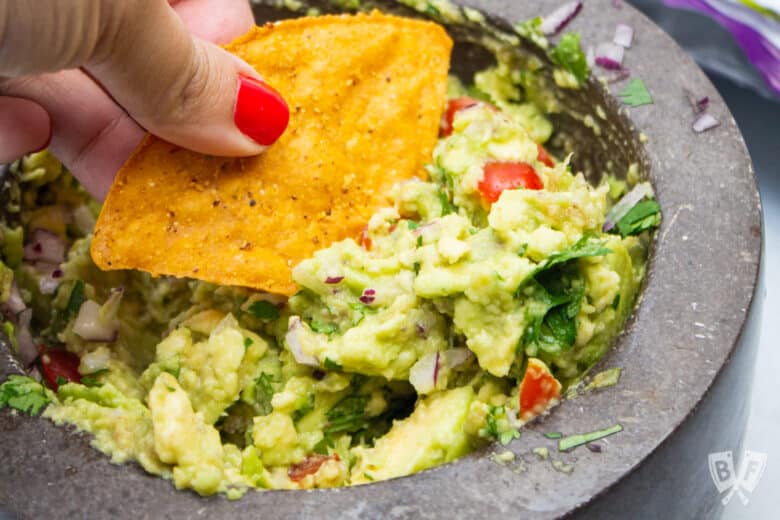 Tortilla chip scooping up guacamole.