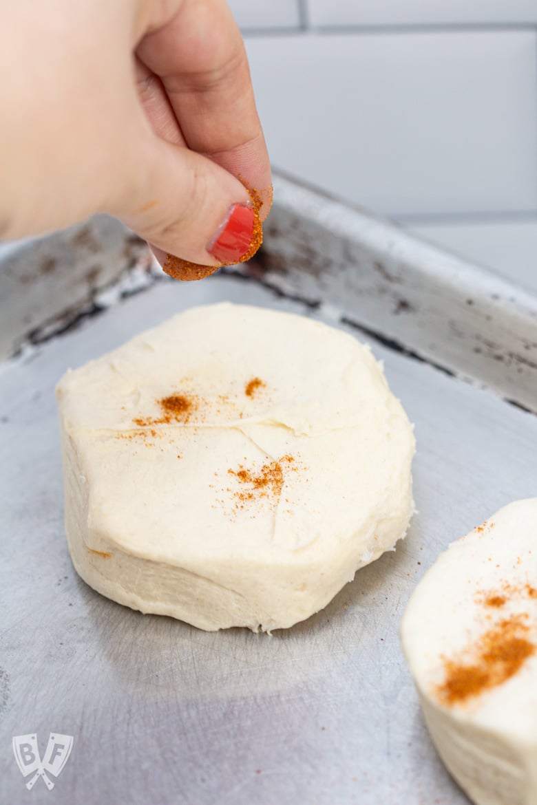Sprinkling cayenne pepper on top of canned biscuits.