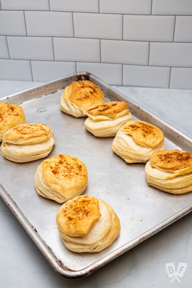 A sheet pan of cooked biscuits topped with cayenne pepper and sweet paprika.