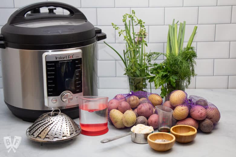 Instant Pot and ingredients for making potato salad with fresh herbs.