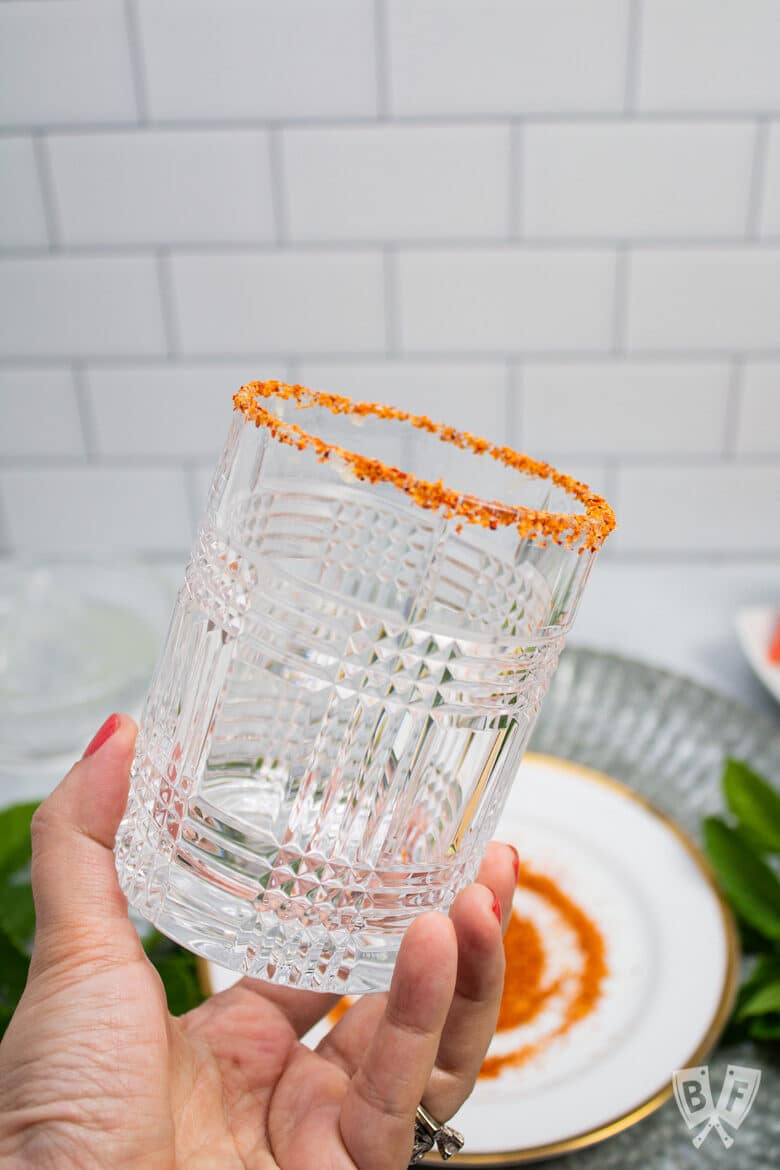 Cocktail glass rimmed with Tajín seasoning.