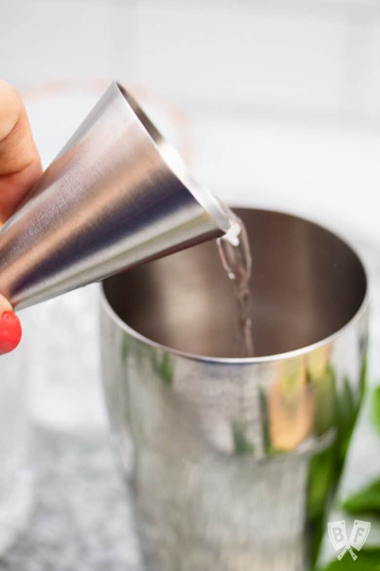 Pouring tequila into a cocktail shaker.