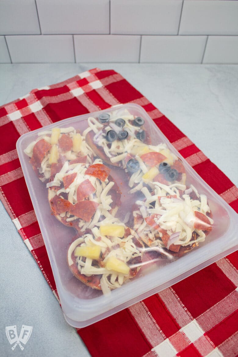 Reusable freezer with mini pizza bagels inside.