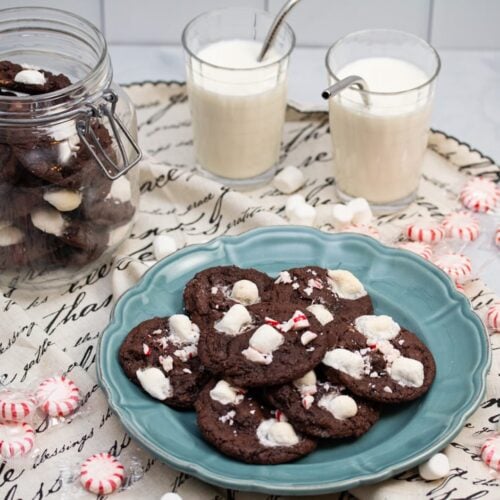 Milk and cookies surrounded by peppermints and mini marshmallows.
