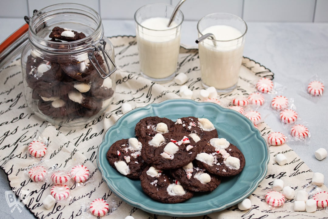 Milk and cookies surrounded by peppermints and mini marshmallows.