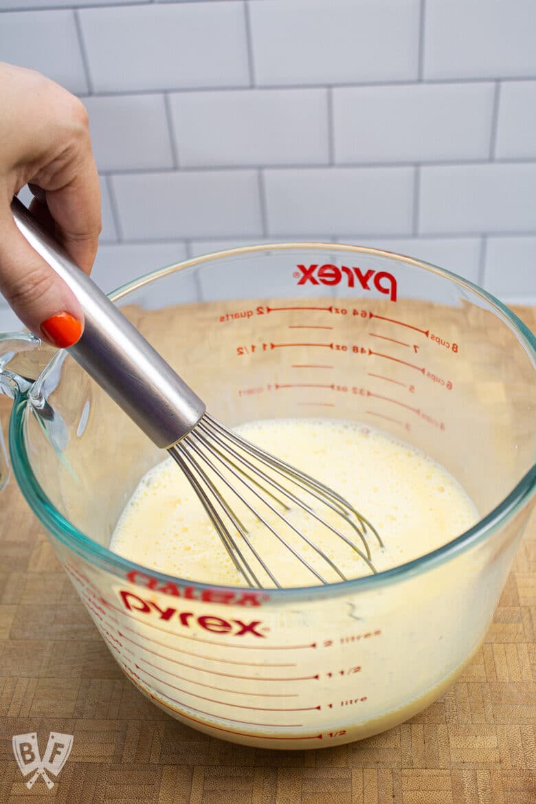 Whisking milk and eggs together.