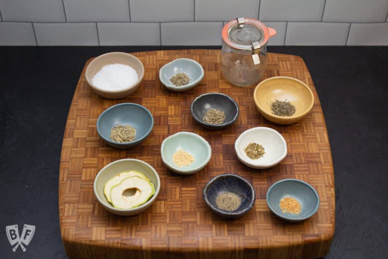 Butcher block with bowls of ingredients for a dry brine seasoning blend.