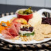 Cheese board featuring a layered gorgonzola fruit torta.