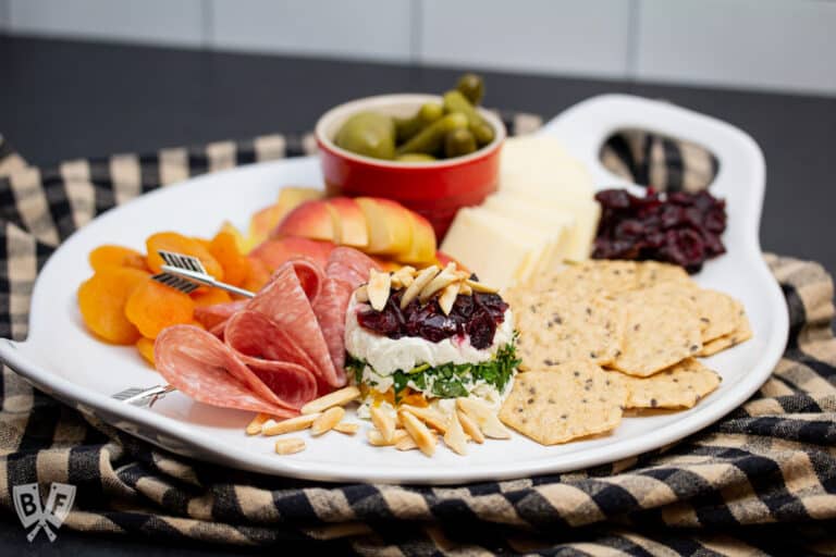 Cheese board featuring a layered gorgonzola fruit torta.