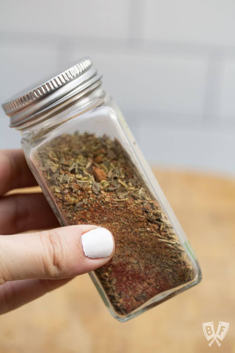 Shaking a spice jar to combine fajita seasoning ingredients.