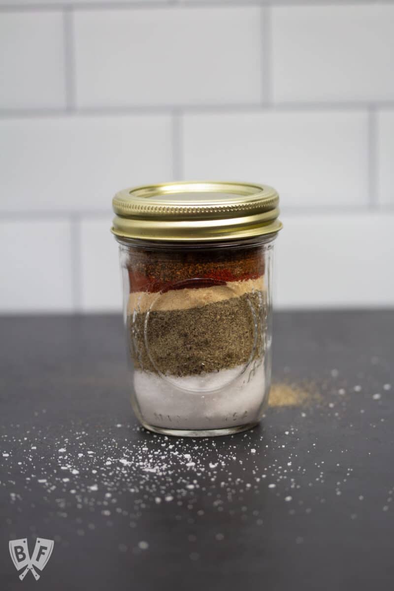 Glass jar filled with layers of spices.