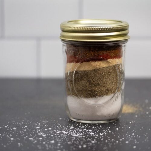 Glass jar filled with layers of spices.