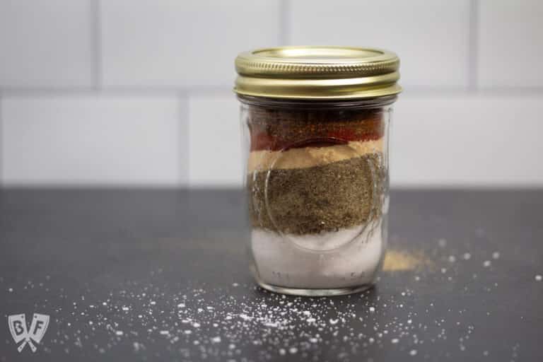 Glass jar filled with layers of spices.