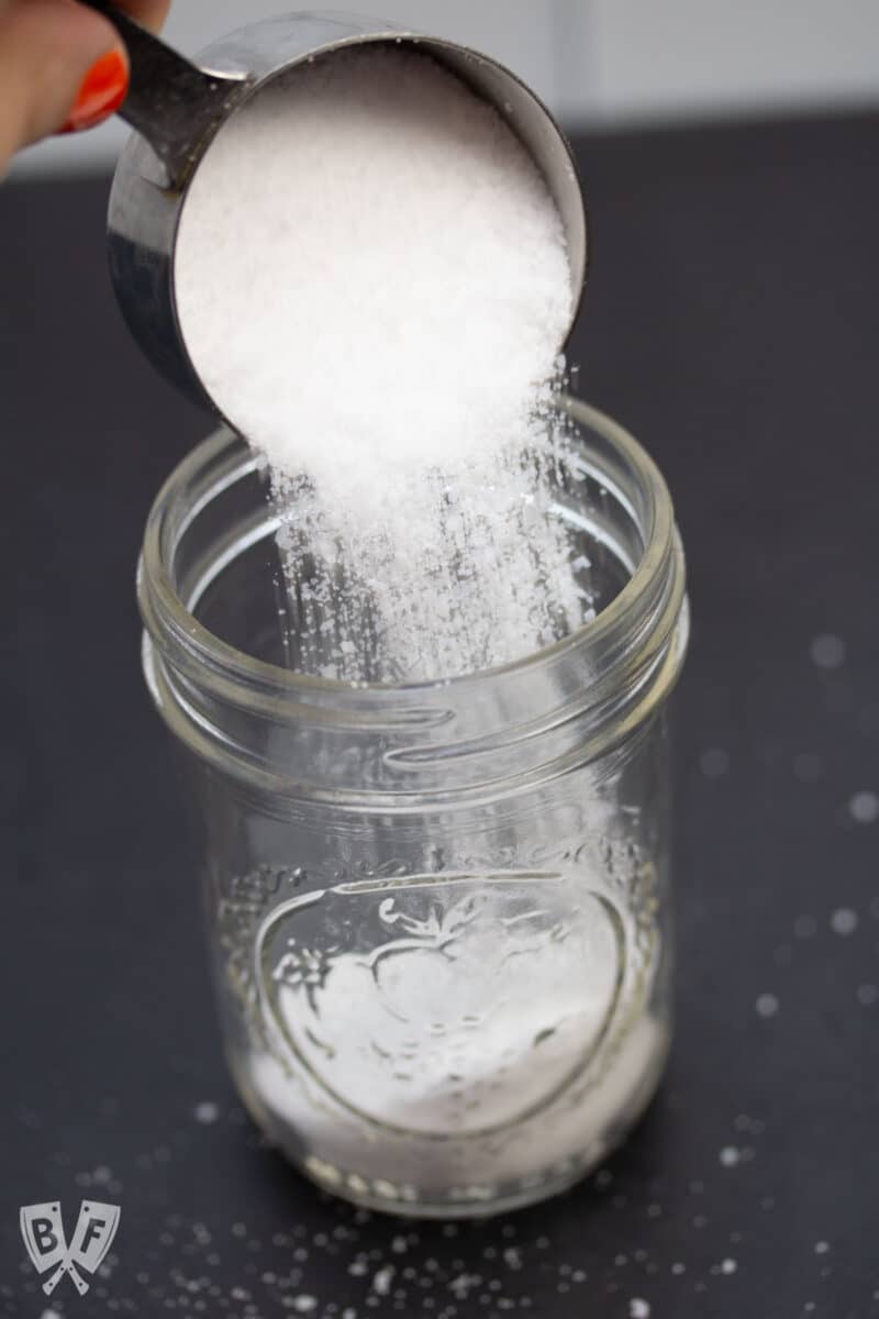 Pouring kosher salt into a glass jar.