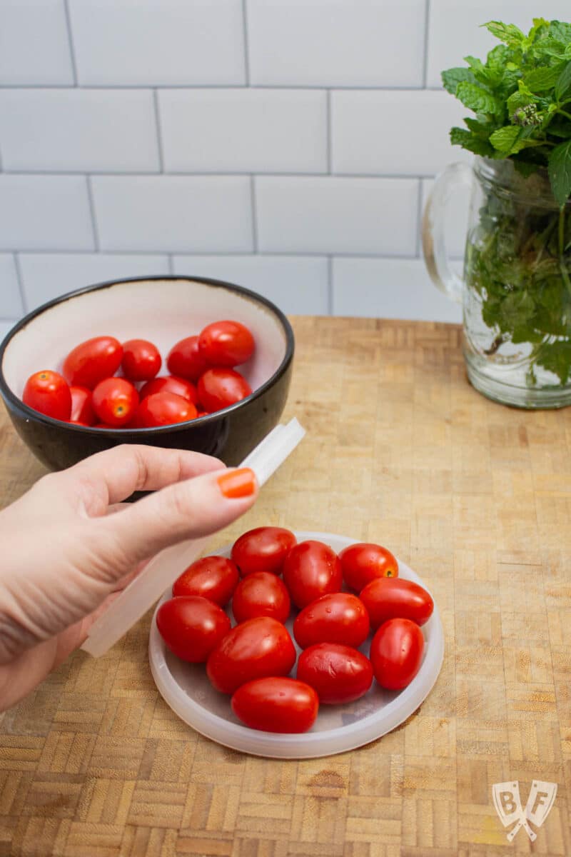 Prepping grape tomatoes to be sliced for salad.
