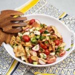 Bowl of fattoush salad with serving utensils.