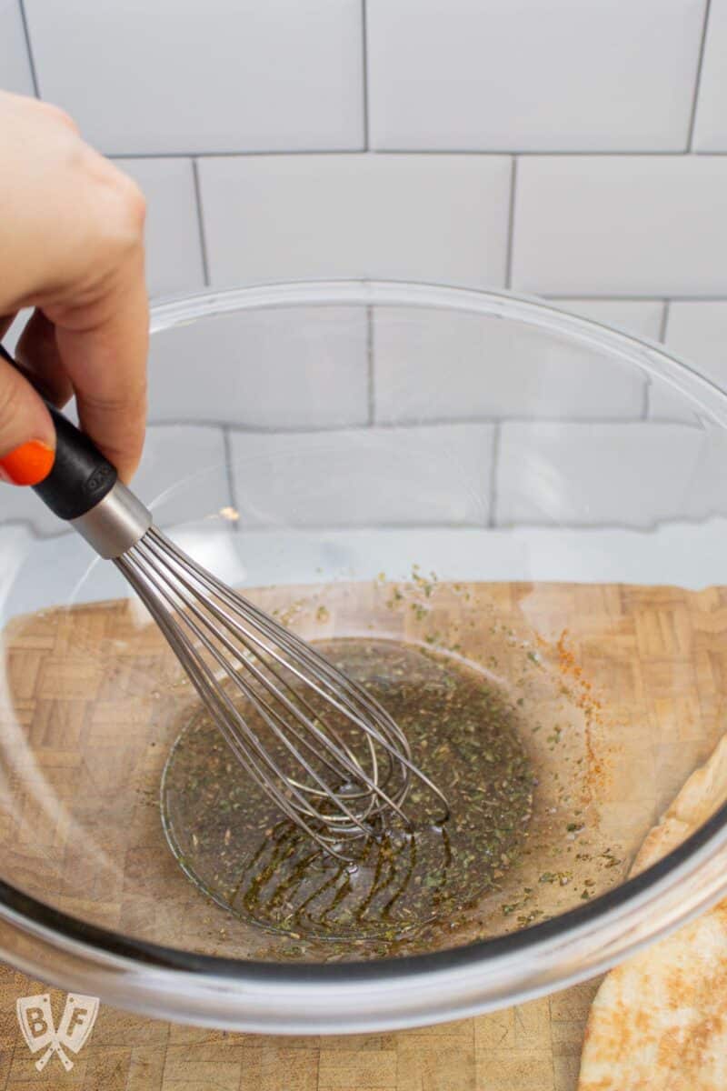 Whisking seasoning and oil together for pita chip coating.