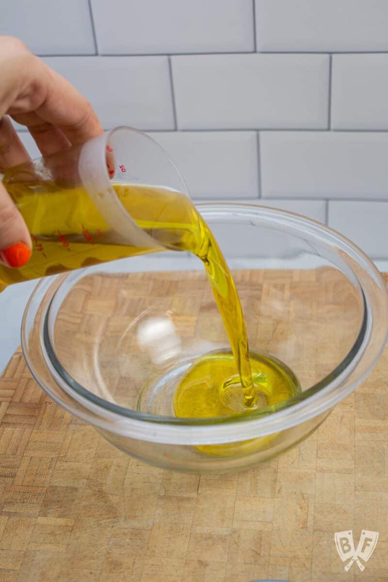 Pouring olive oil into a bowl.