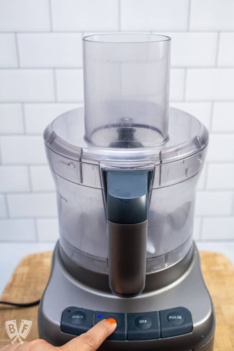 Turning a food processor on low speed.