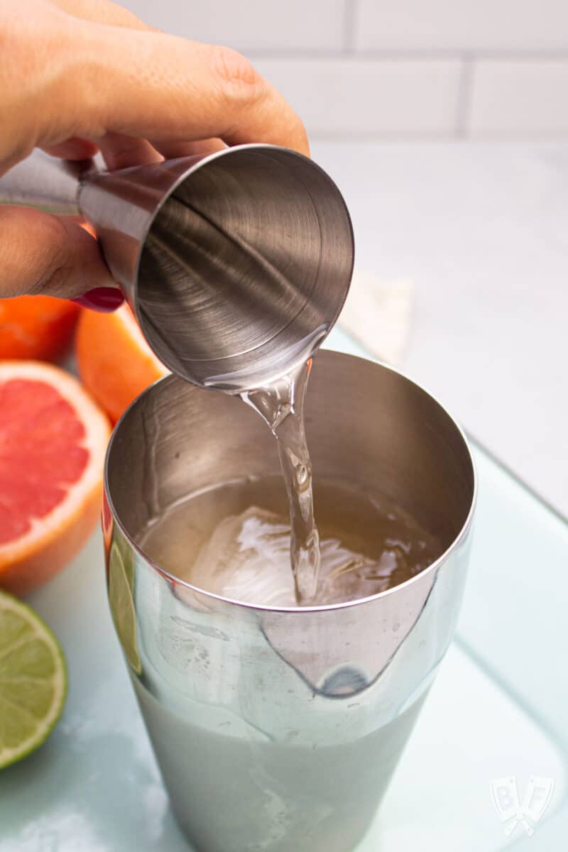 Pouring tequila into a cocktail shaker.