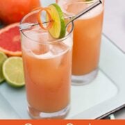 2 guava cocktails on a tray with fresh fruit in the background.