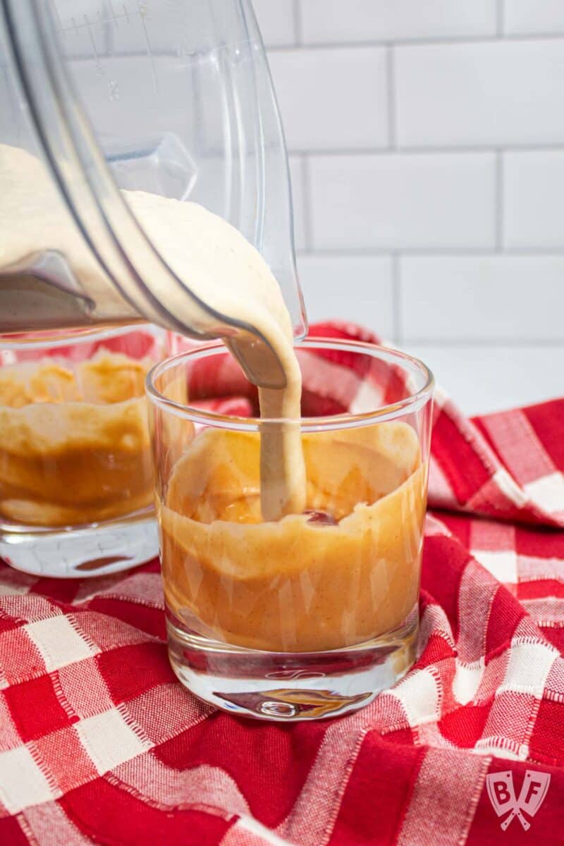 Pouring a milkshake into a peanut butter-lined glass.