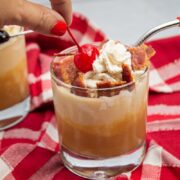 Placing a maraschino cherry on a peanut butter banana milkshake.