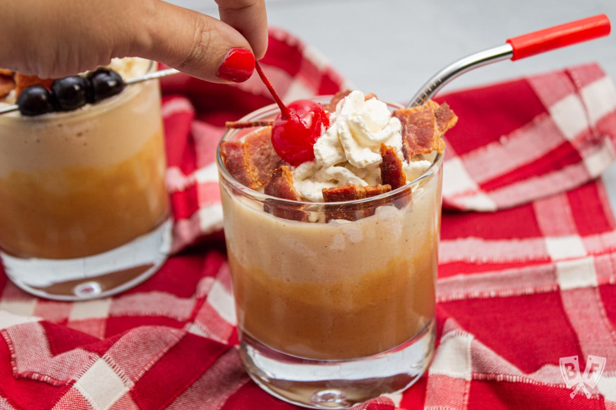 Placing a maraschino cherry on a peanut butter banana milkshake.