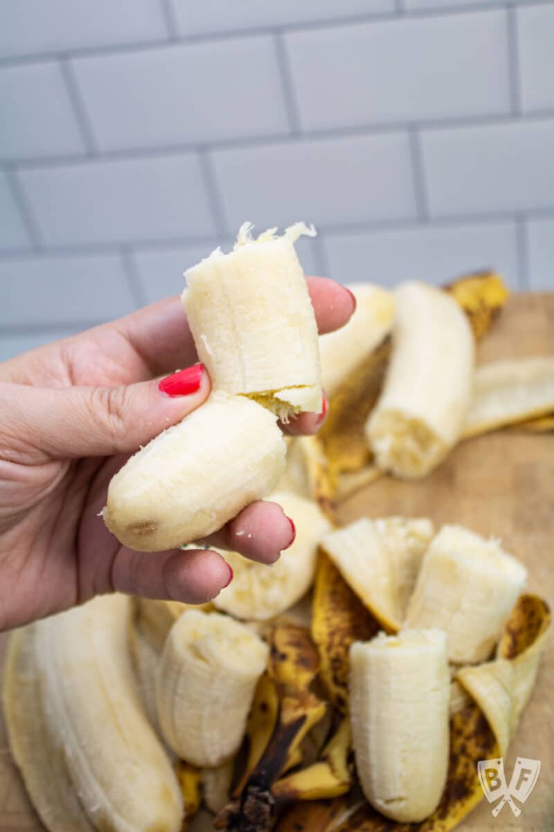 Breaking a banana into pieces to freeze.