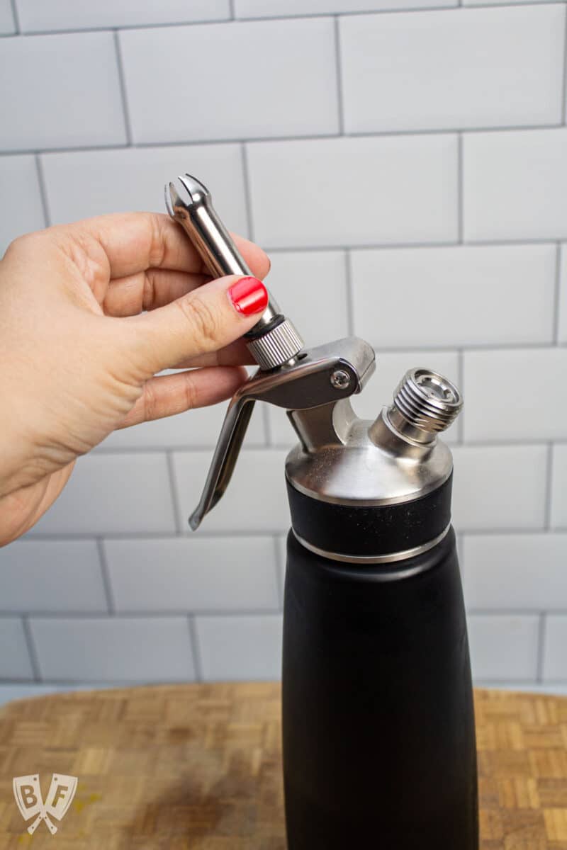 Attaching the decorator tip to a whipped cream dispenser.