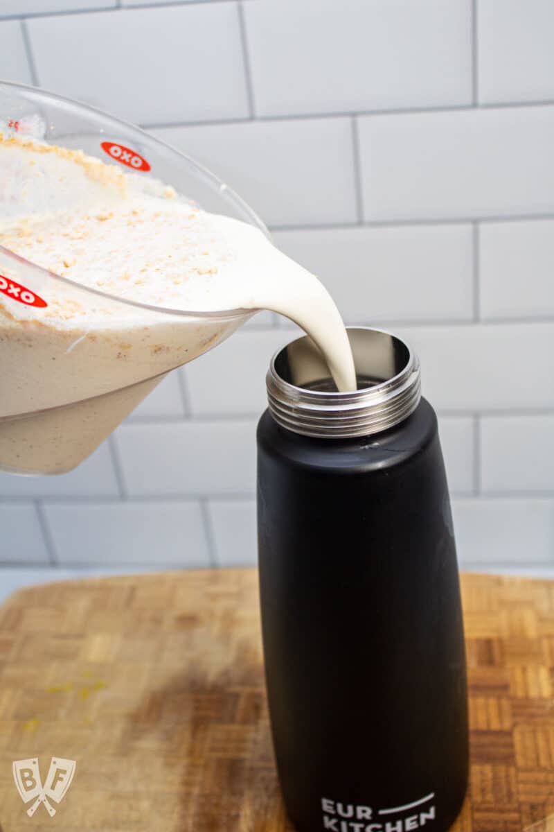 Pouring ingredients for peanut butter maple whipped cream into a whipped cream dispenser.