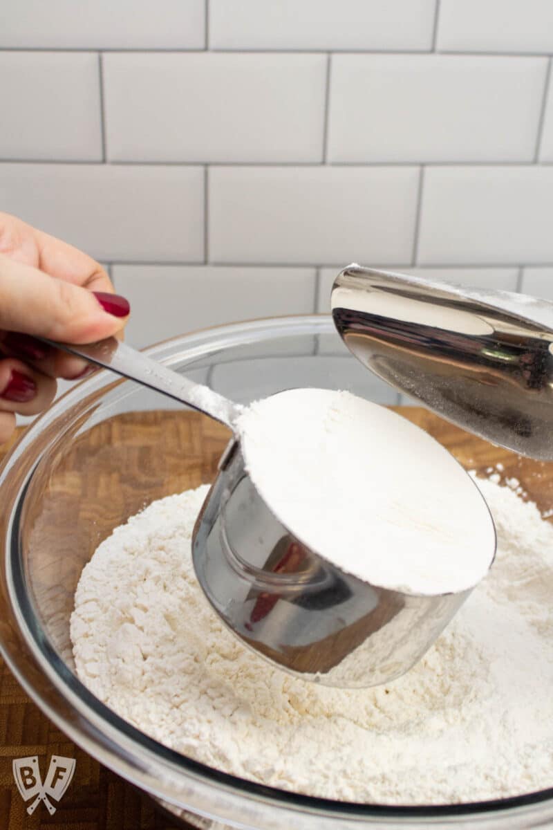 Leveling off a measuring cup full of flour.