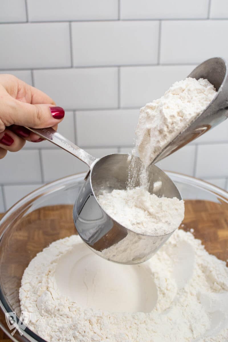 Pouring flour into a measuring cup.