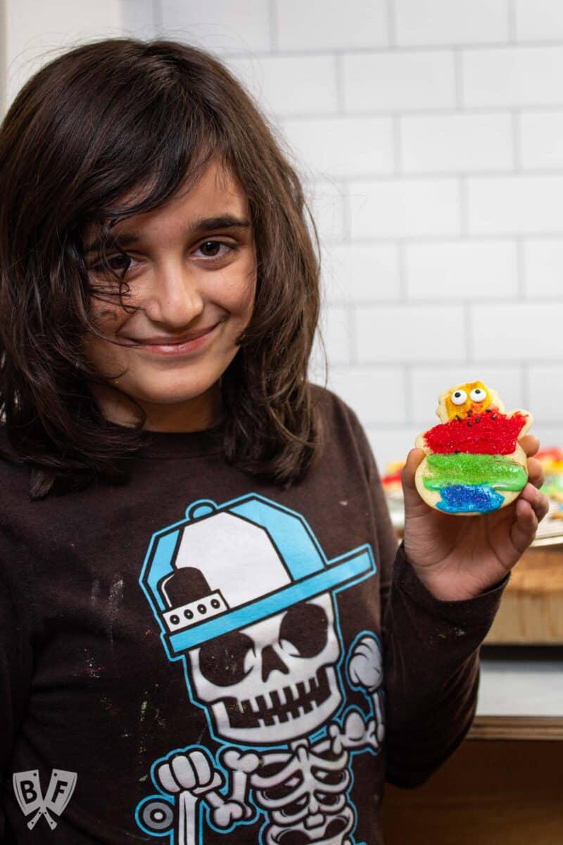 Boy holding a decorated Christmas cookie.