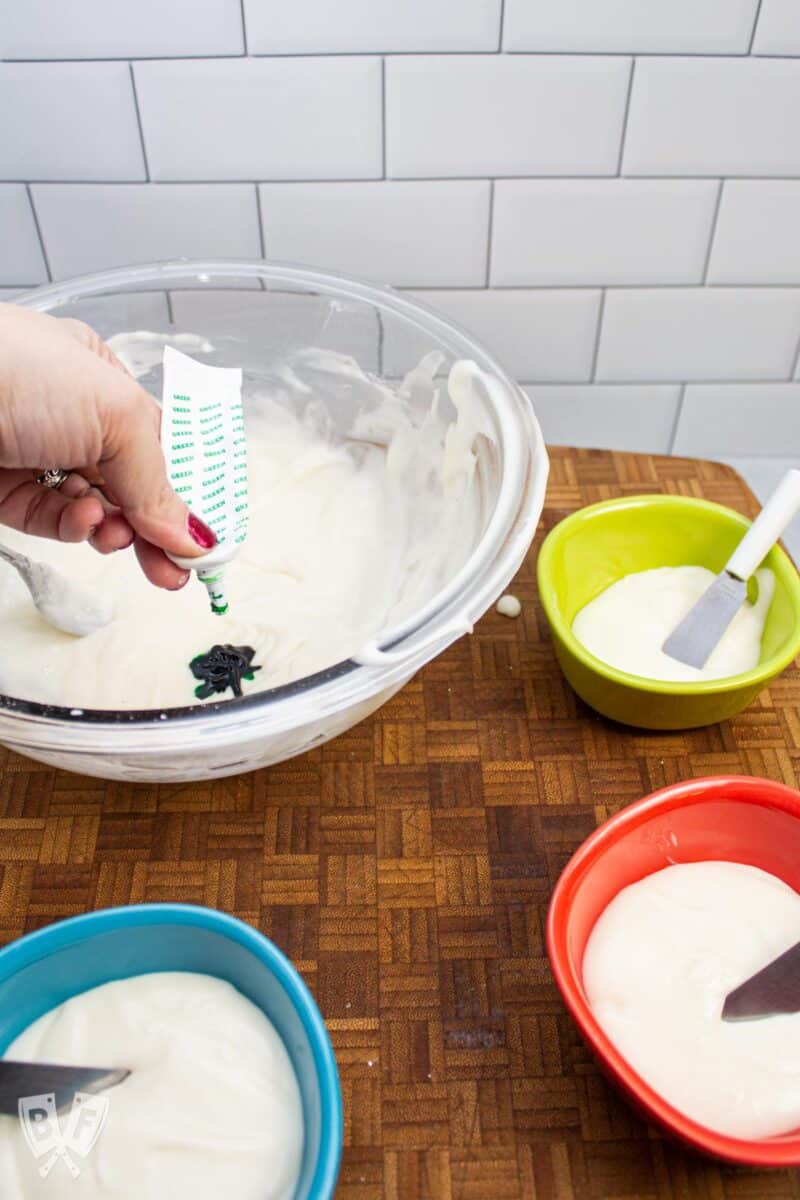 Adding food coloring to bowls of white icing.