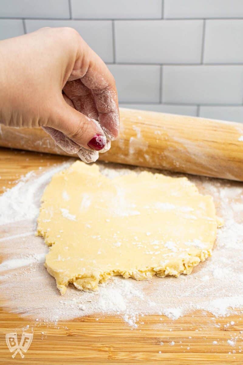 Sprinkling flour onto sugar cookie dough to roll out.