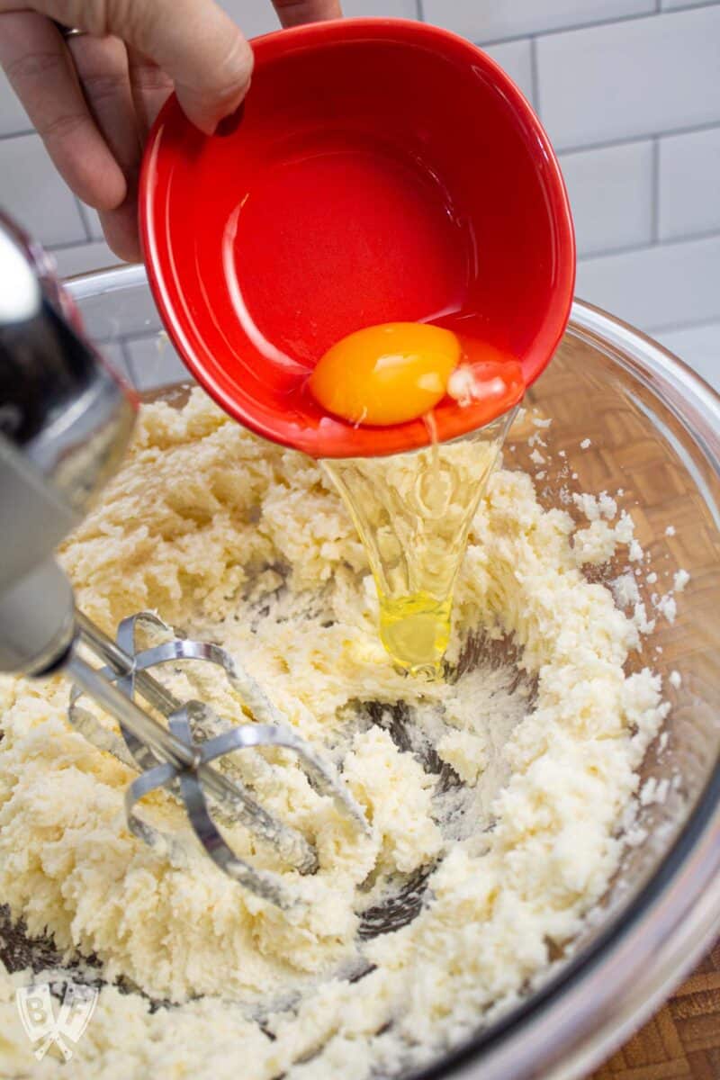 Adding eggs to a bowl while making cookie dough.