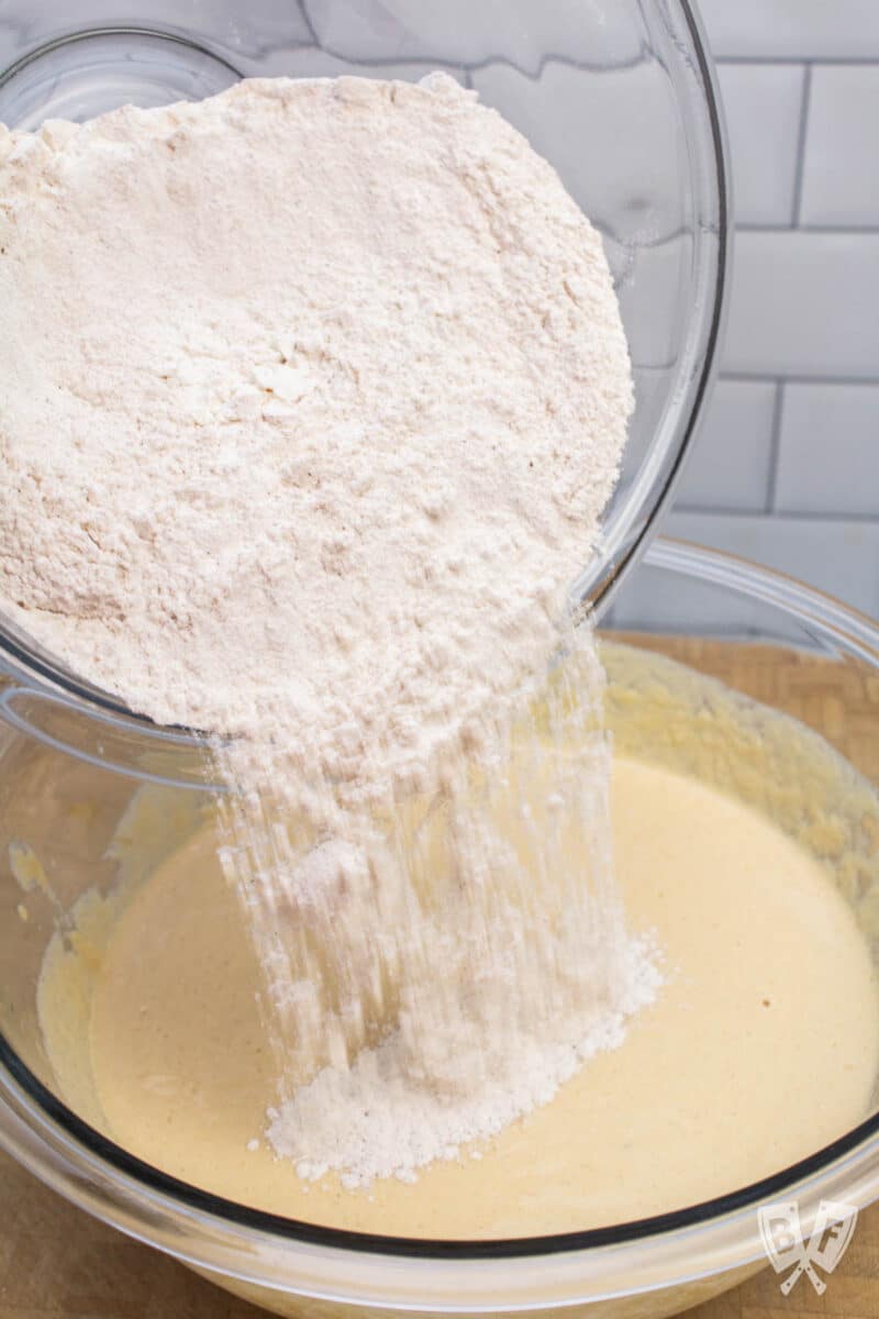 Pouring the dry ingredients into the wet ingredients for gingerbread pancakes.