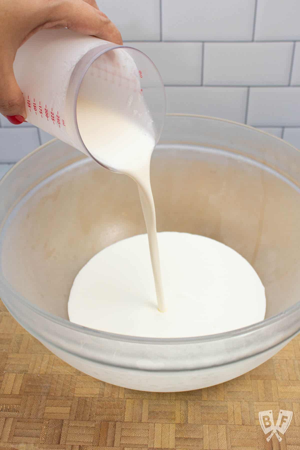 Pouring heavy cream into a bowl.