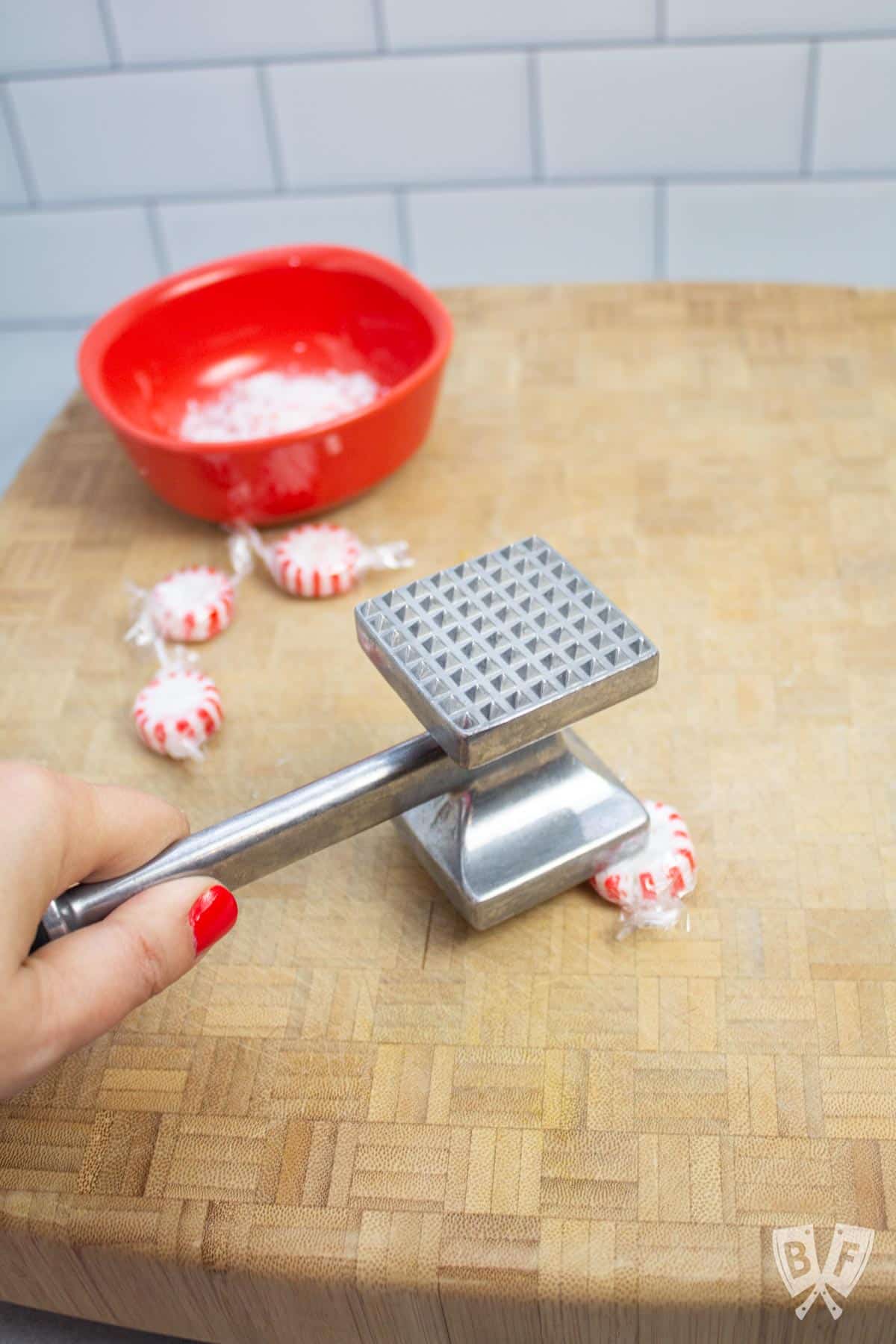Crushing peppermint candies with a meat tenderizer.