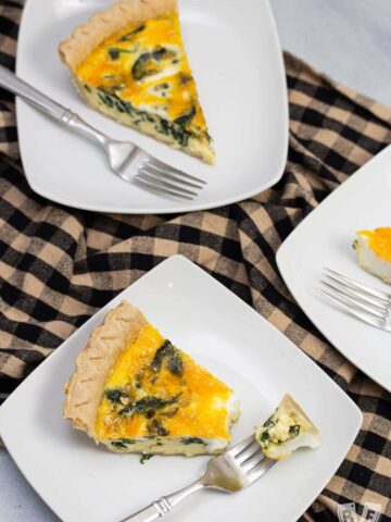 Overhead view of spinach and cheddar quiche with forks.