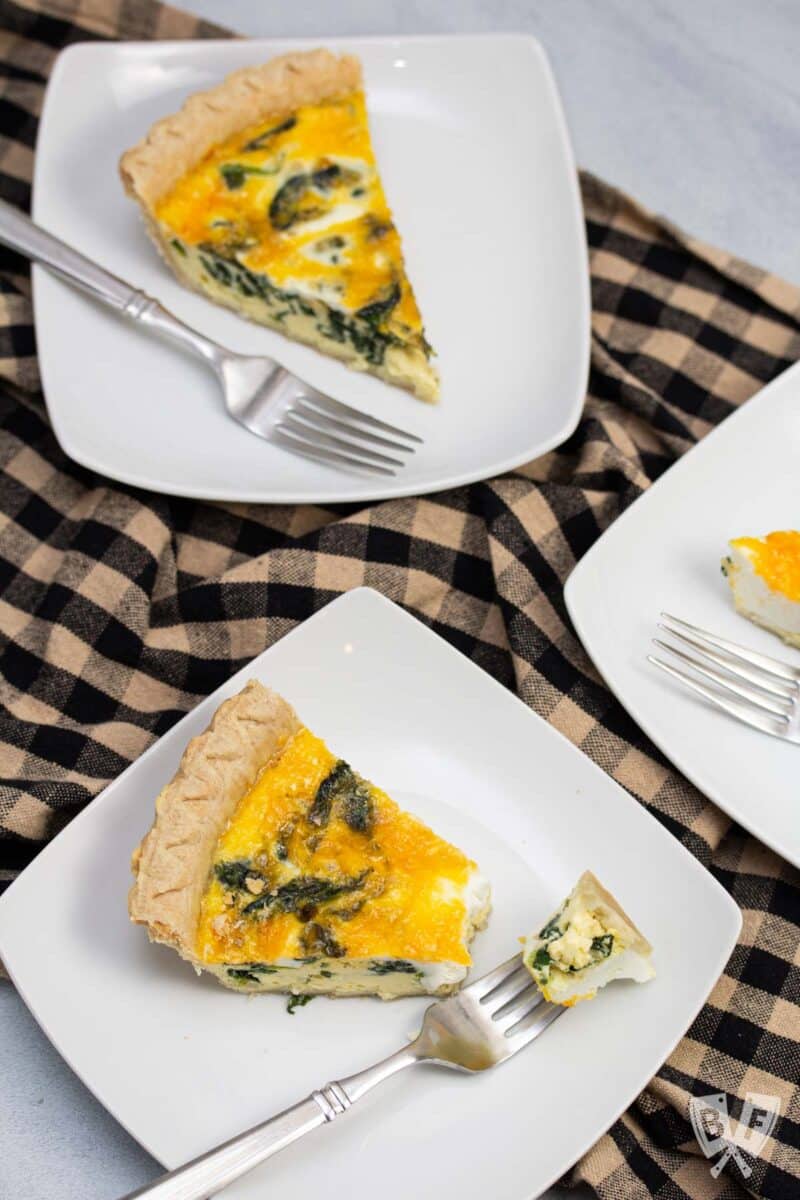 Overhead view of spinach and cheddar quiche with forks.